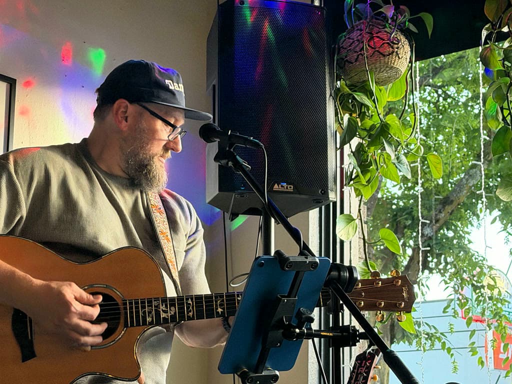 Jeremy Ross playing acoustic guitar during a live performance.